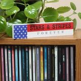 The Holiday Aisle® 7" Patriotic “Stars & Stripes Forever" Tabletop Décor Wood in Brown | 1.65 H x 0.8 W x 7.25 D in | Wayfair