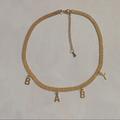 Urban Outfitters Jewelry | Baby Gold Metal Ribbon Letter Pendant Choker | Color: Gold | Size: Os