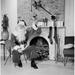 Posterazzi Portrait of Santa Claus Sitting in Front of a Fireplace & Holding a Christmas Present Poster Print - 18 x 24 in.