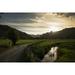 A gravel road between fields as the sun sets behind the mountains; Lake District Cumbria England Poster Print (19 x 12)