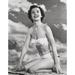Young woman sitting on beach and smiling Poster Print (24 x 36)
