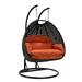 LeisureMod Mendoza Charcoal Wicker Hanging 2 Person Egg Swing Chair with Stand & Orange Cushions