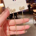 Boucles d'oreilles pendantes à long pompon pour femmes boucles d'oreilles pendantes nœud papillon