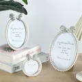 A bow shaped pearl studded diamond frame with a 3/6/7 inch oval photo frame suitable for children's