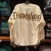 Disney Sweaters | Disneyland Castle Spirit Jersey Nwt | Color: Cream/Gold | Size: Various