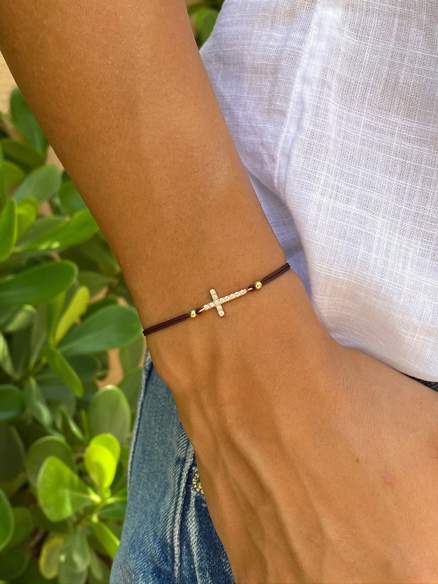 Bracciale con croce in zirconia cubica. Bracciale con croce in oro rosa e zirconia cubica. Bracciale regolabile. Bracciale con cordino. Bracciale con