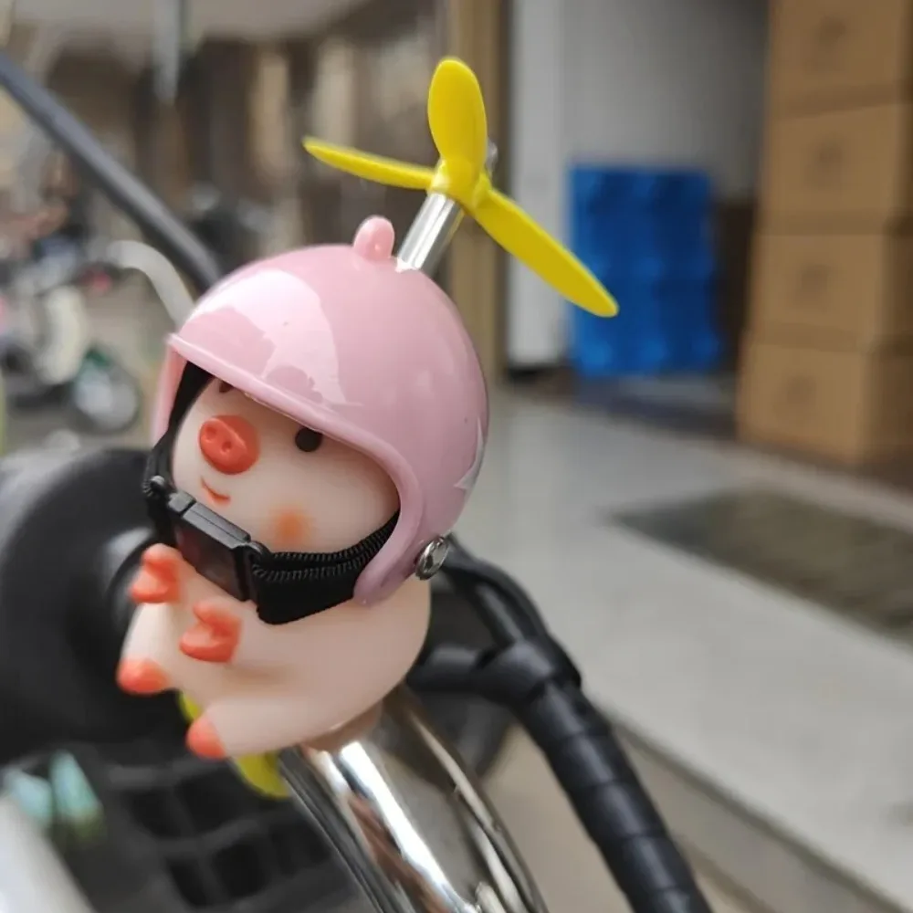 Niedliche kleine Schweinedekoration, die einen Helm, eine Schweineautofigur, eine Motorrad- und Fahrradfiguren tragen. Image