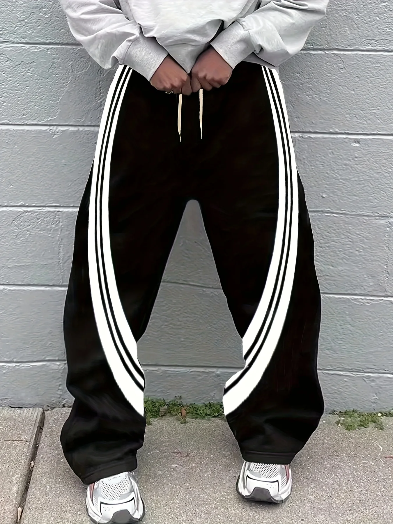 Trendige und lässige Herren-Jogginghose mit auffälliger schwarzer und weißer Farbe – blockierenden Streifen, strahlt einen modernen und stilvollen Look Image