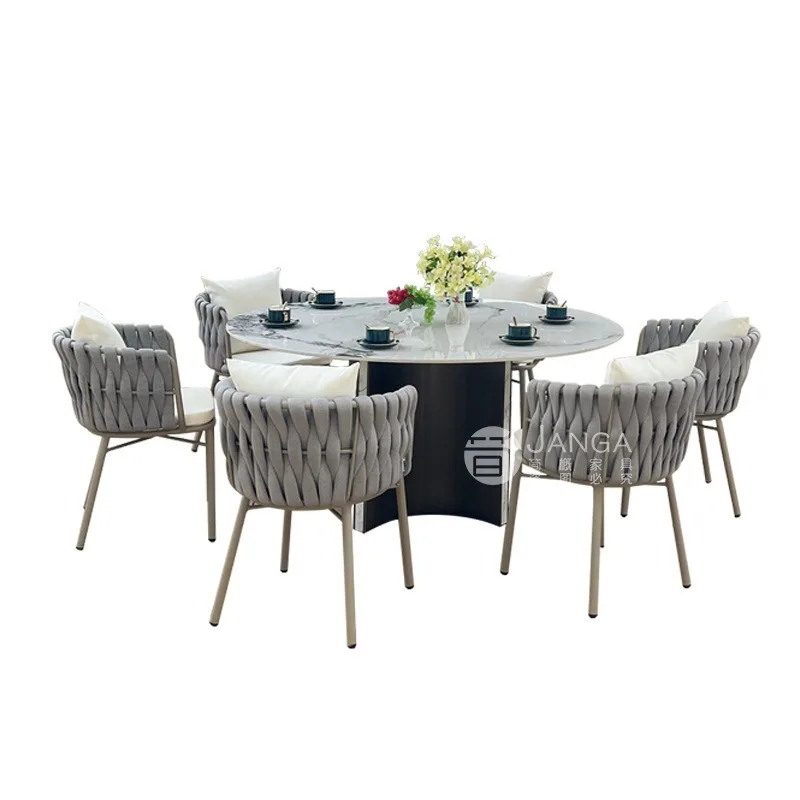 Gartenmöbel-Set für den Außenbereich: Esstisch und Stühle aus Rattan für Terrasse, Hotel oder Ferienhaus, mit rundem Steinplattentisch. Image