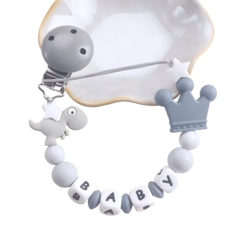 Personalisierter Baby-Schnullerclip aus Silikon mit Dinosaurier- und Kronenanhänger, Alphabetperlen, Anti-Drop-Design Image