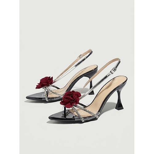 Schwarze, spitze Stiletto-Sandalen mit silbernen Riemchen und roter Blume für Damen, ideal für Hochzeitsgäste im Garten. Image