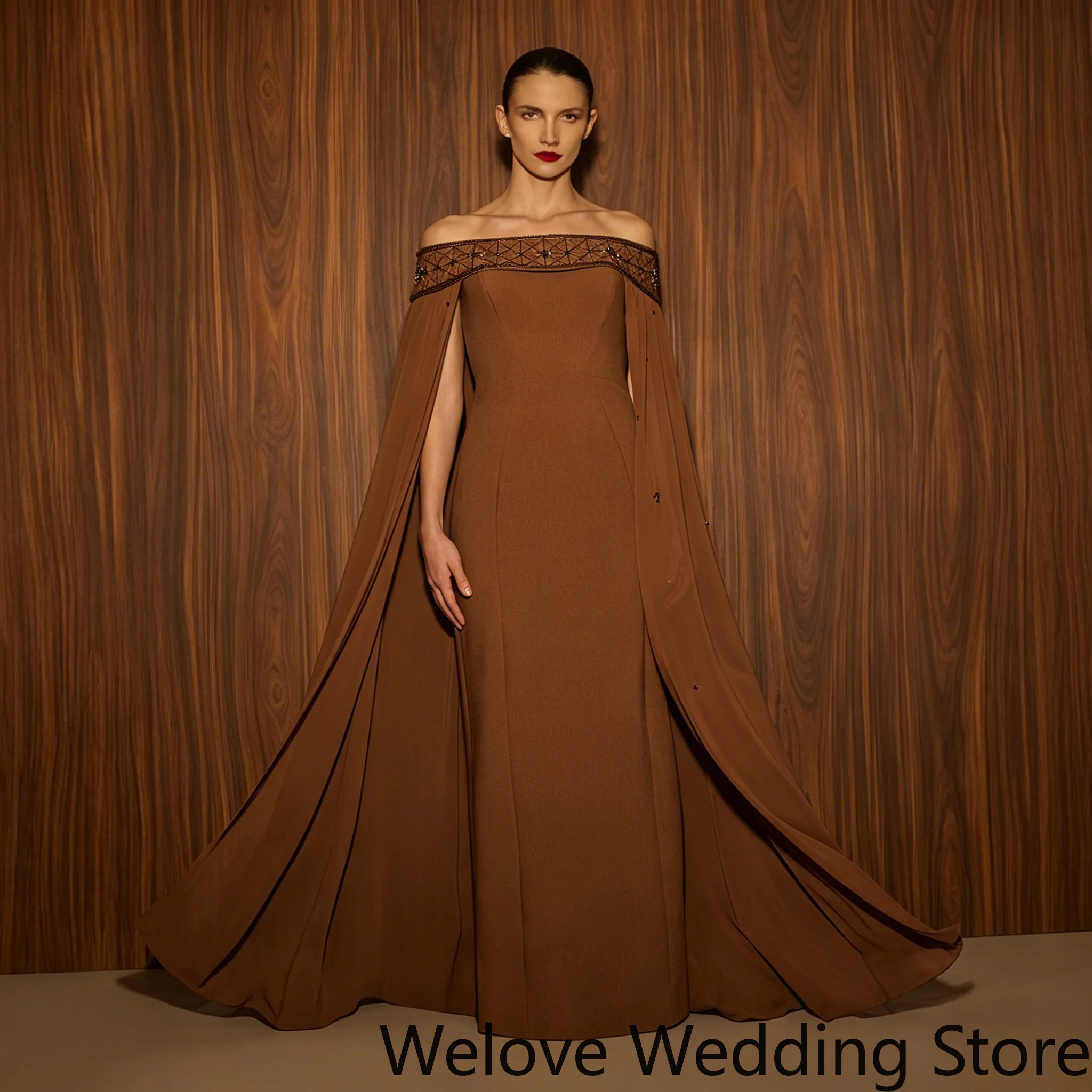 Elegant Brown Formal Evening Gown Featuring an Off-the-Shoulder Neckline with Intricate Embellishments, a Dramatic Cape Overlay