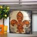 Fleur De Lis Living Cross Fleur-De-Lis on Wooden Block Wall Décor in Brown/Green/Orange | 9 H x 9 W x 1.5 D in | Wayfair